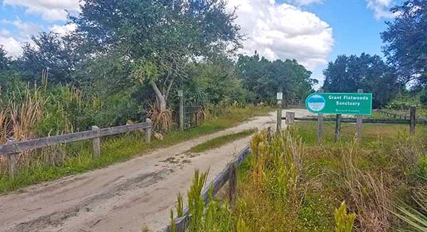 Dirt road entrance with sign that reads Grant Flatwoods Sanctuary.