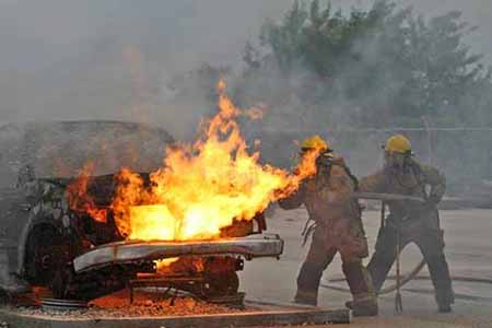 Firefighters putting out car fire