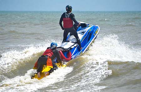 Two Ocean Rescue lifeguards riding on a jet ski in the ocean in Cocoa Beach.