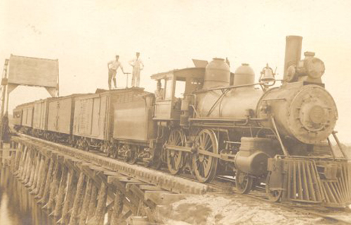 Two workers standing on top of train.