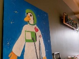 Painting of a duck in a space suit.