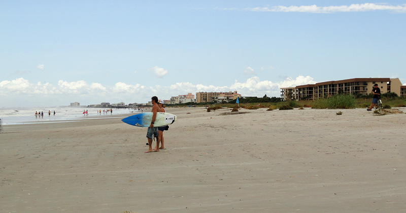 a surfer walking out to the ocean.