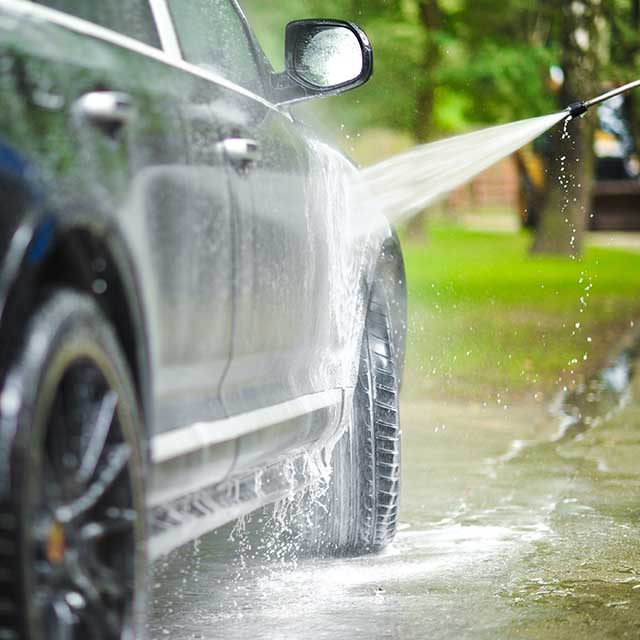 Washing car with sprayer.