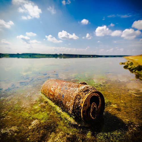 Old rusty can on riverbank.