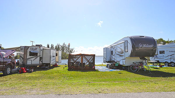 Campers and a tent near river.