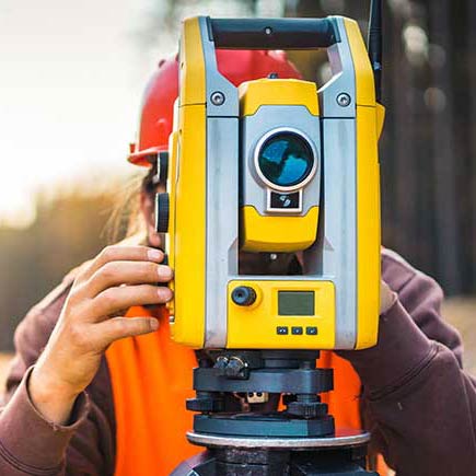 Surveyor using total station.