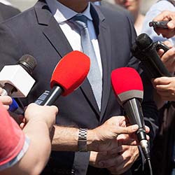 Press conference reporters with microphones