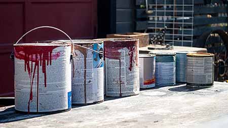 Multiple cans of used household paint.